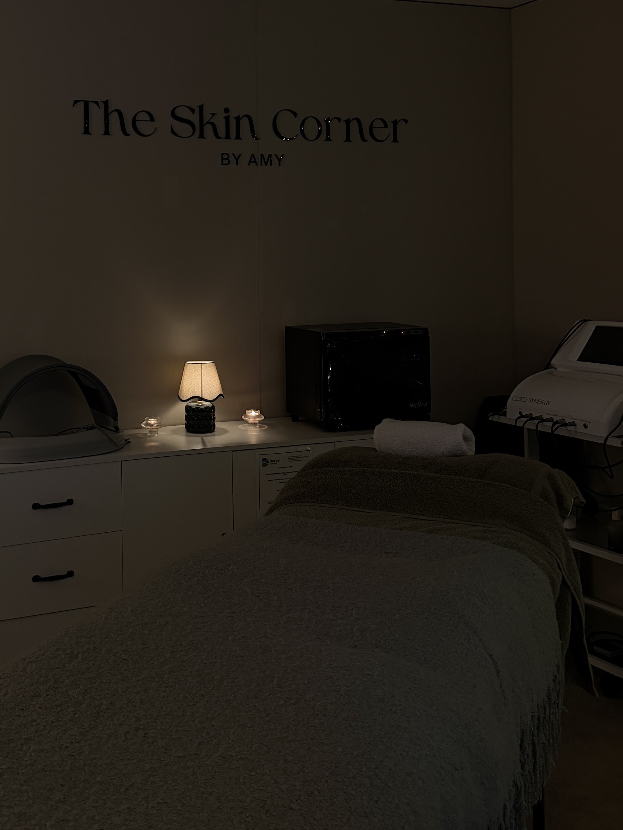 The treatment room by lamplight, with The Skin Corner by Amy lettering on the wall
