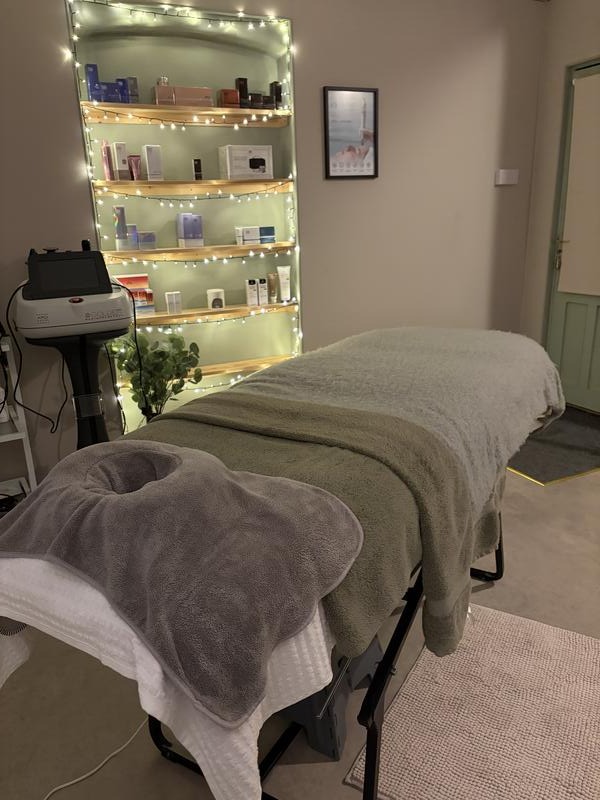The treatment room with the couch ready and product shelves lit with fairy lights