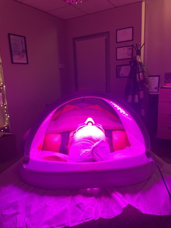 A client relaxing under the Dermalux LED light
